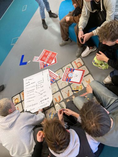 Eine kleine Gruppe hockt vor Spielkarten