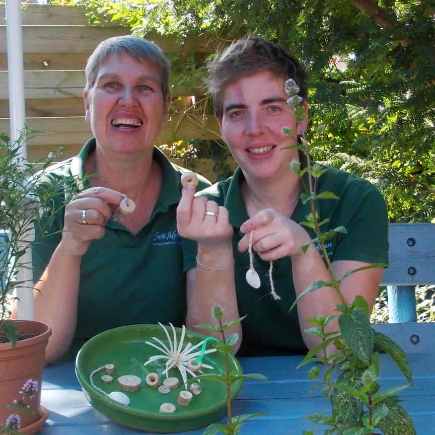 Zwei Personen sitzen am Tisch im Garten