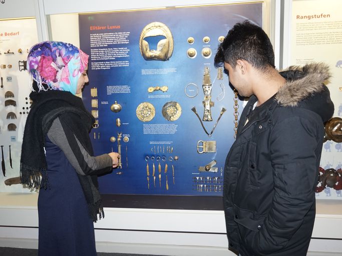 Eine Frau und ein Mann betrachten eine Ausstellungswand