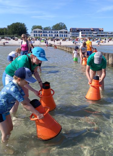 Erwachsene und Kinder beobachten mit Aquaskopen den Meeresgrund