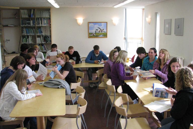 Workshopteilnehmende sitzen gruppenweise an Tischen